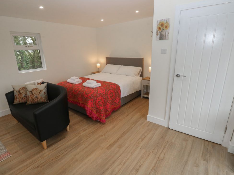 A bedroom with a bed and couch at Heidiaway Lodge Porth