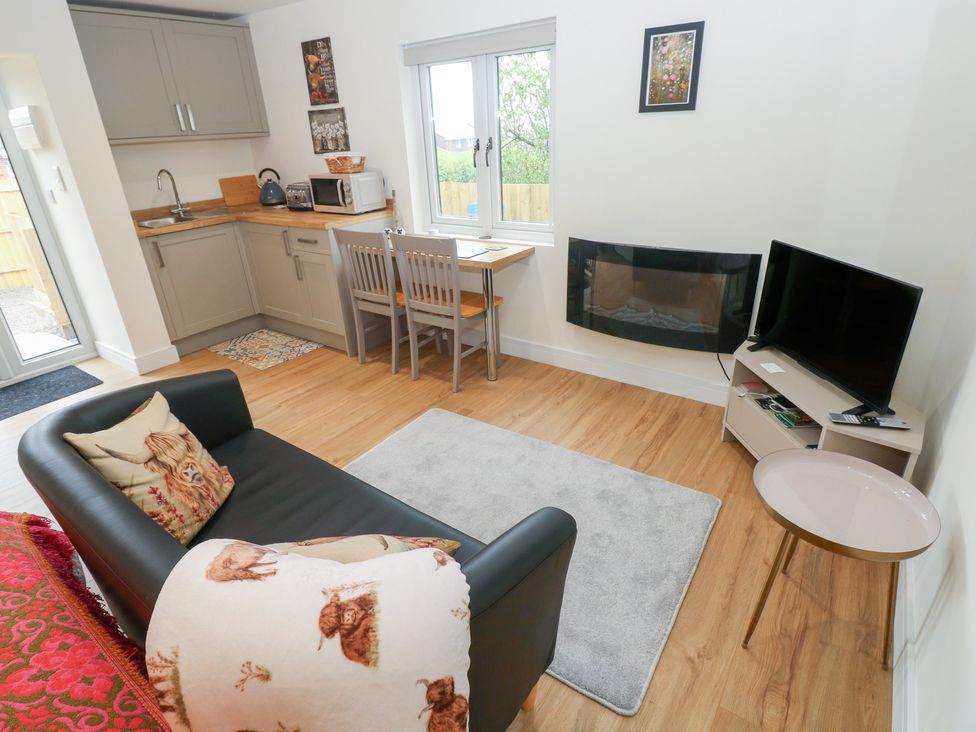 A living room with a kitchenette and seating area at Heidiaway Lodge in Gilfach Goch