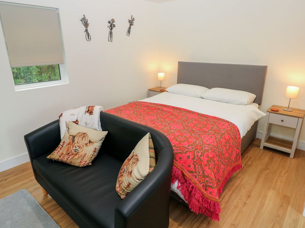 A bedroom with a bed and sofa at Heidiaway Lodge in Gilfach Goch