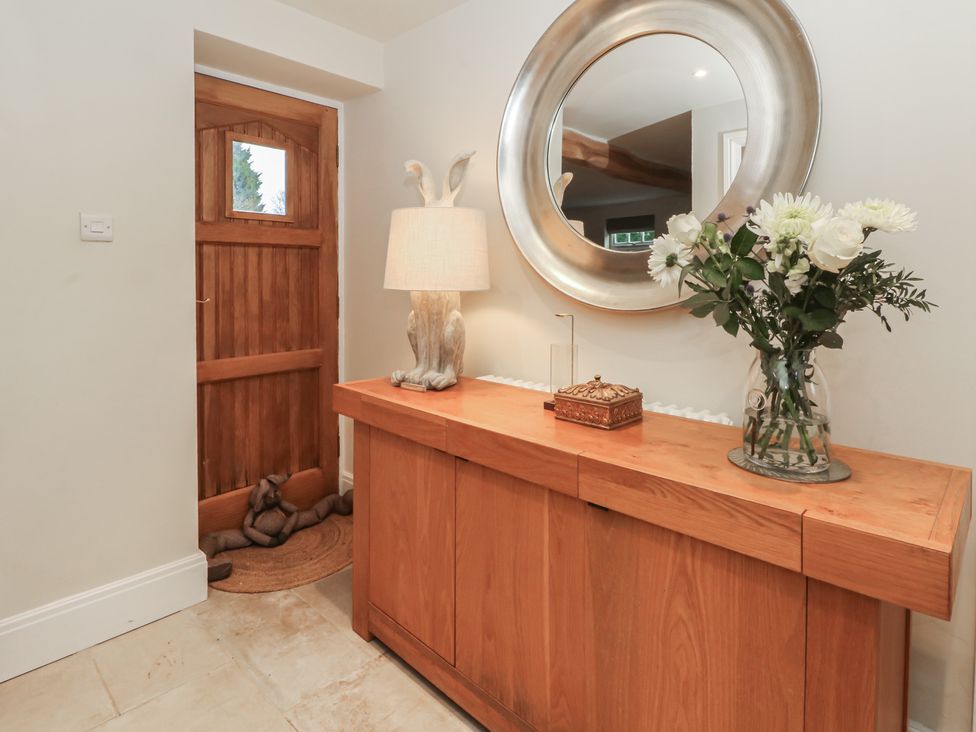 A hallway with a console table and mirror at The Winnows in Knutsford