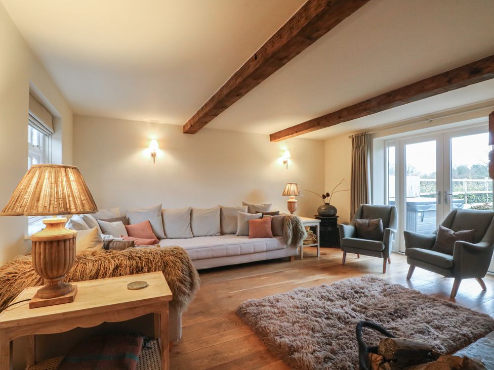 A living room with a sofa and armchairs at The Winnows in Knutsford