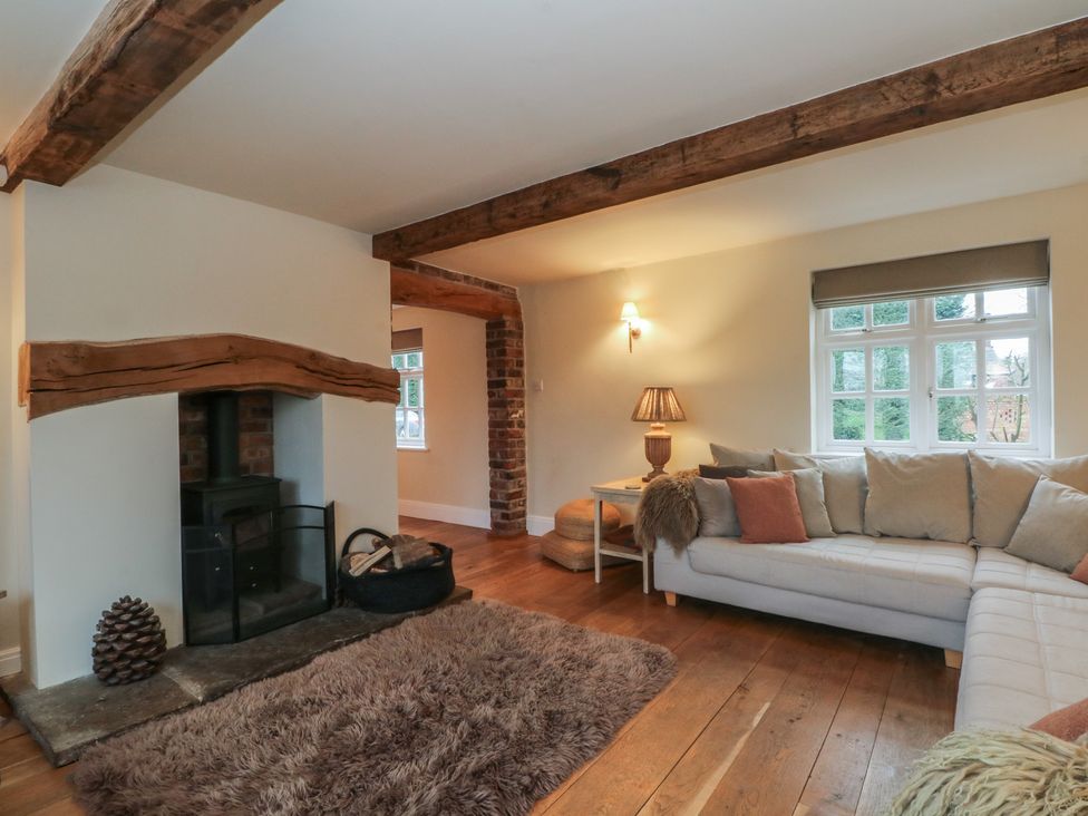 A living room with a fireplace and sofa at The Winnows in Knutsford