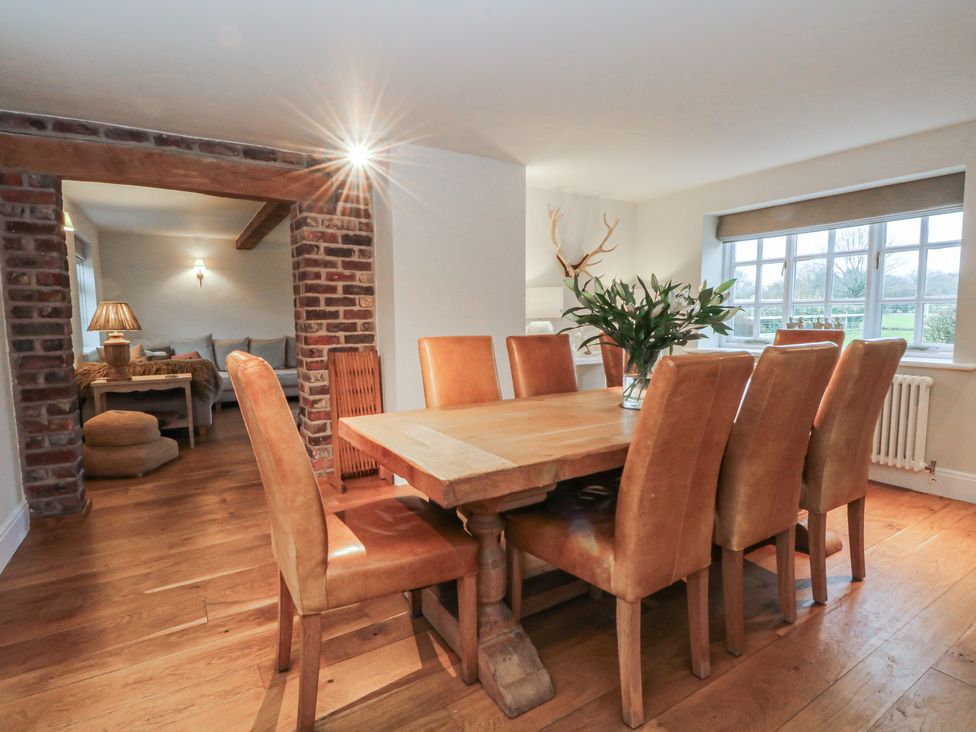 A dining room with a wooden table and chairs at The Winnows in Knutsford