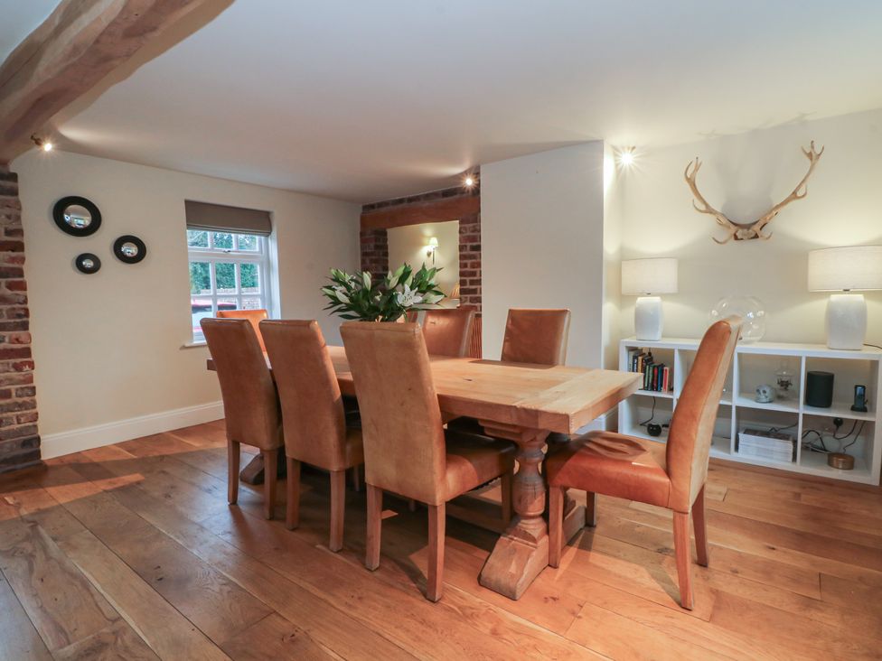 A dining room with a wooden table and chairs at The Winnows in Knutsford