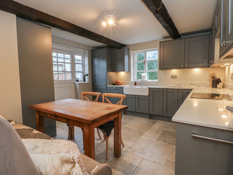 A kitchen with a wooden table and chairs at The Winnows in Knutsford