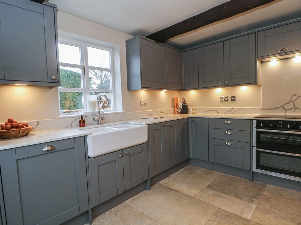 A kitchen with cabinets, sink, and oven at The Winnows in Knutsford