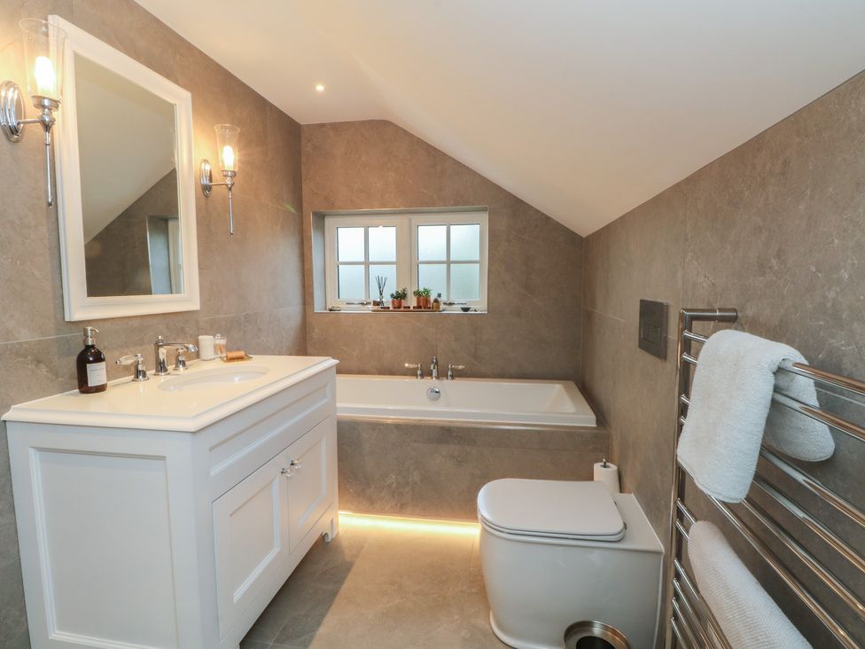 A bathroom with a sink, bathtub, and toilet at The Winnows in Knutsford