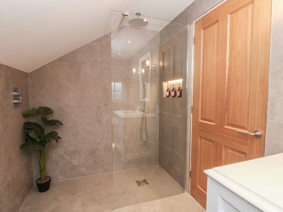 A bathroom with a shower and sink at The Winnows in Knutsford
