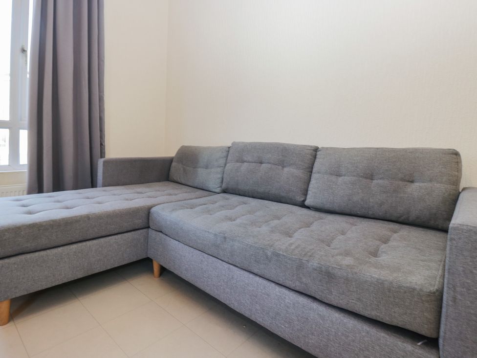 A sofa with grey cushions at Beechtree Timber Lodge 69B in Denny