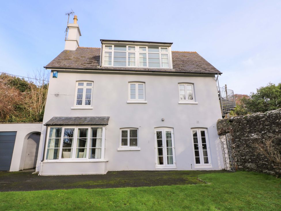 A two-story house with windows and a door in the garden at Blackstone Cottage Salcombe