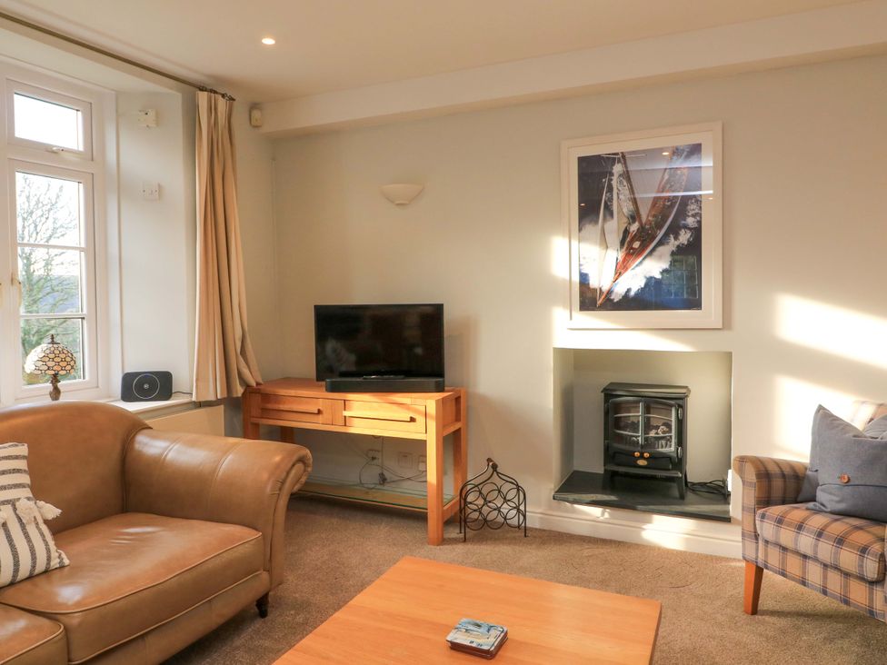 A living room with a television and sofa at Blackstone Cottage in Salcombe