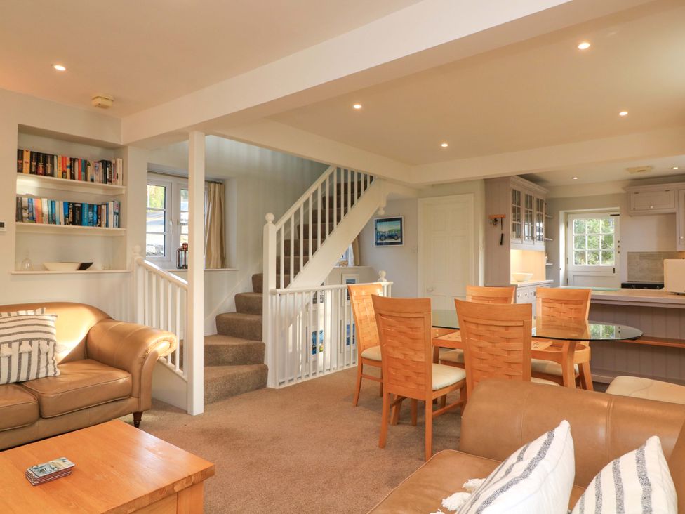 A living room with a sofa and dining area at Blackstone Cottage in Salcombe