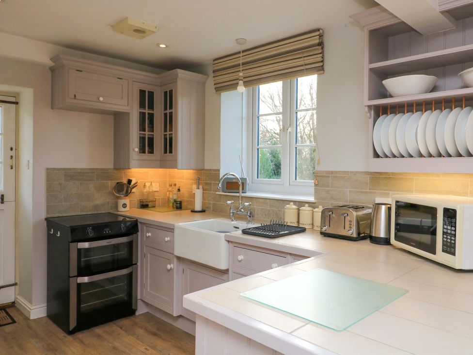 A kitchen with appliances and countertop at Blackstone Cottage in Salcombe