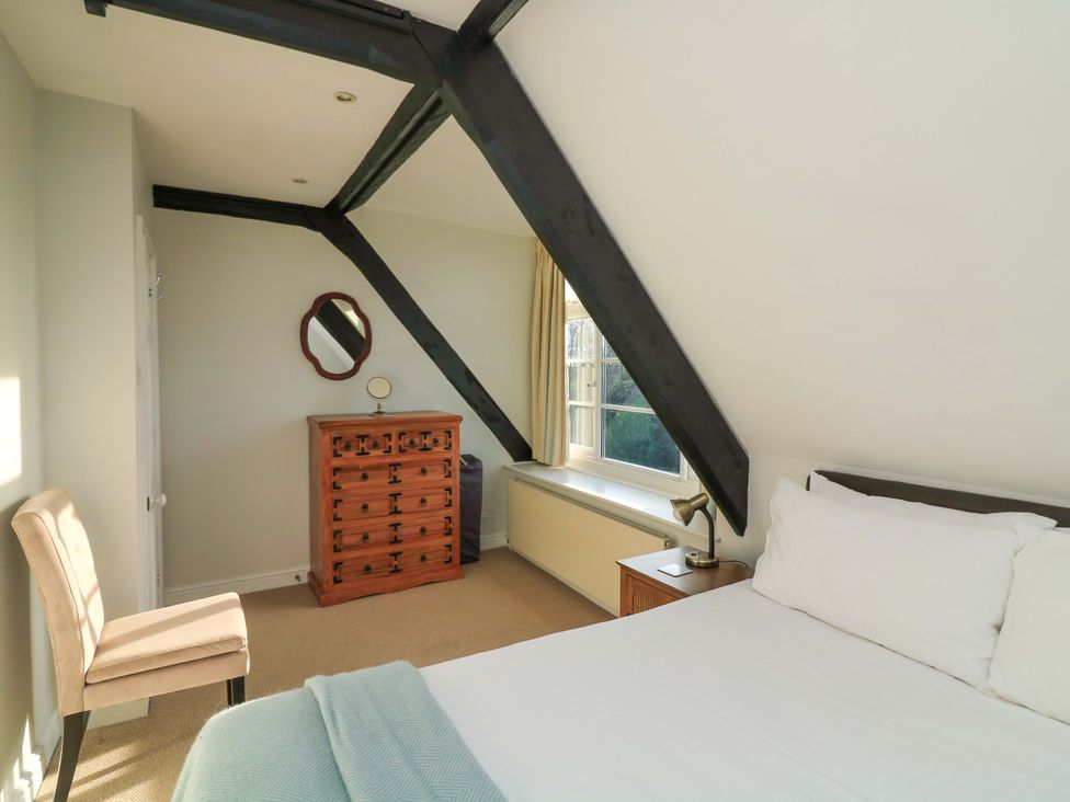 A bedroom with a bed and a dresser at Blackstone Cottage Salcombe