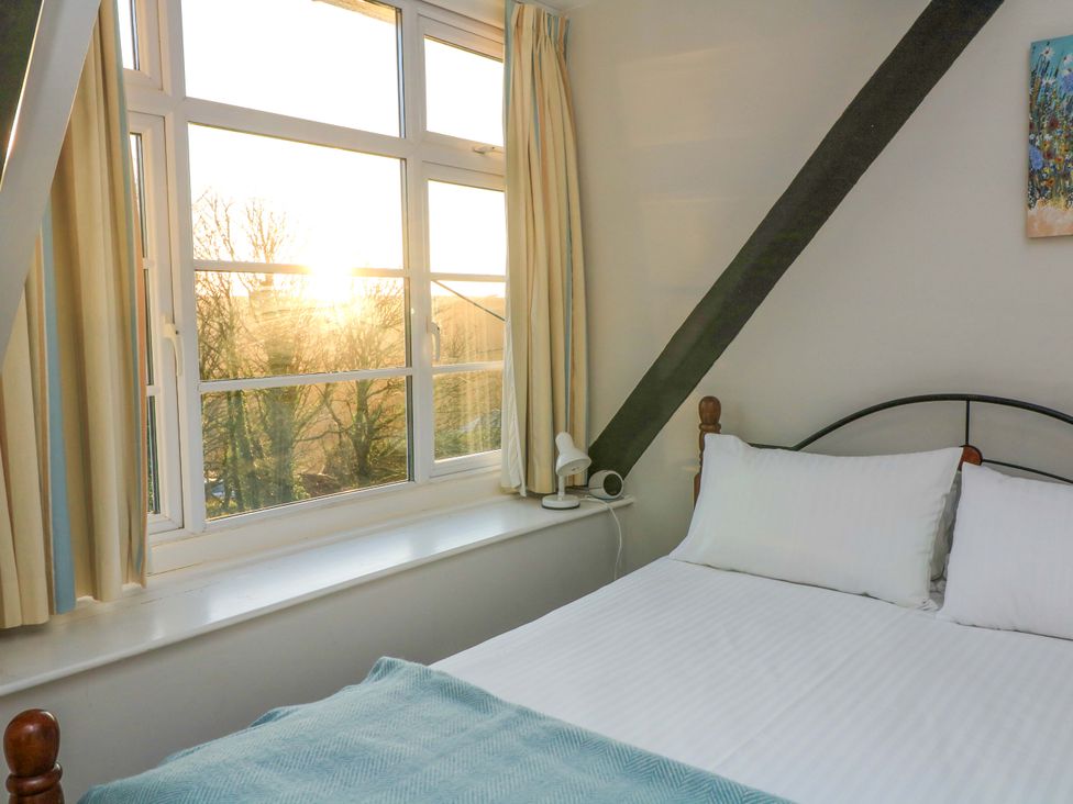 A bedroom with a bed and window at Blackstone Cottage in Salcombe