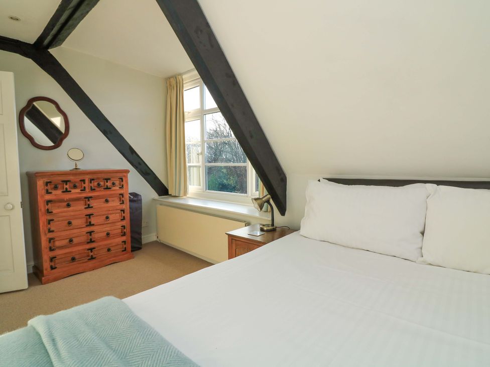 A bedroom with a bed and a chest of drawers at Blackstone Cottage in Salcombe