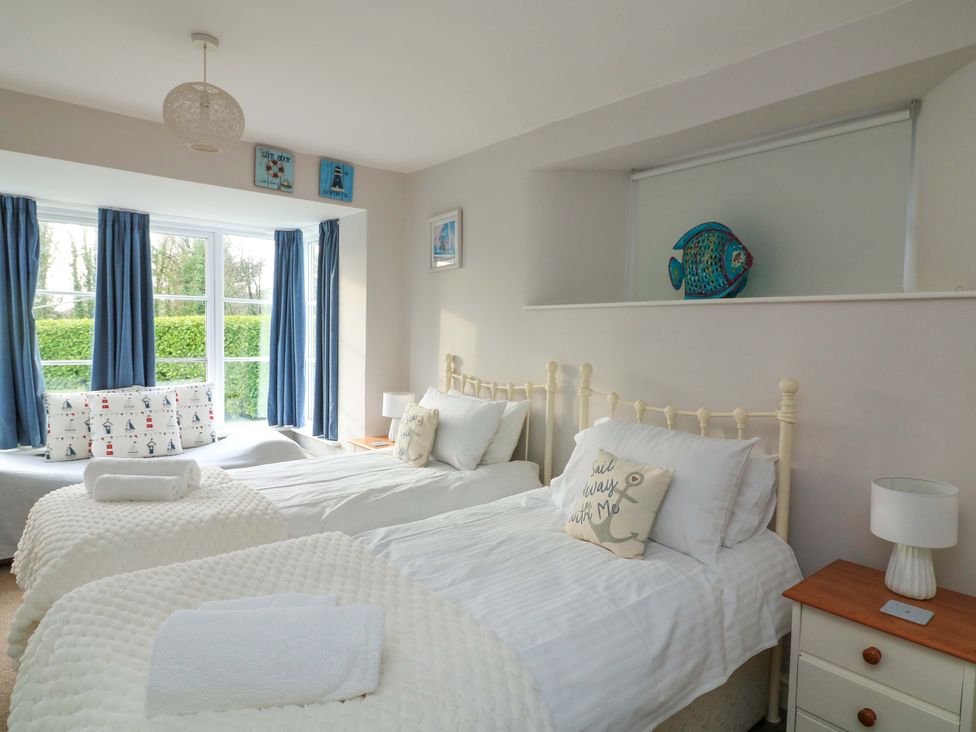 A bedroom with two beds and a window at Blackstone Cottage Salcombe