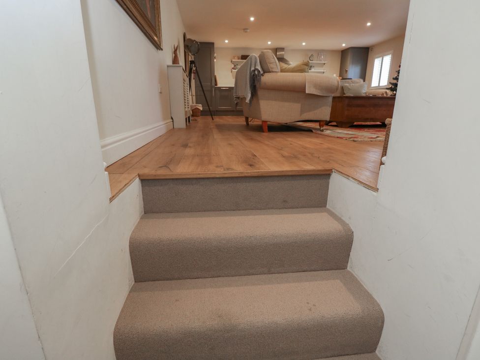 Stairs leading to a living room with furniture at Flat 6