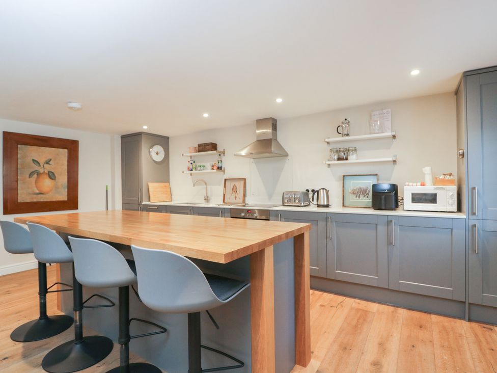 A kitchen with an island and stools at Flat 6 in 