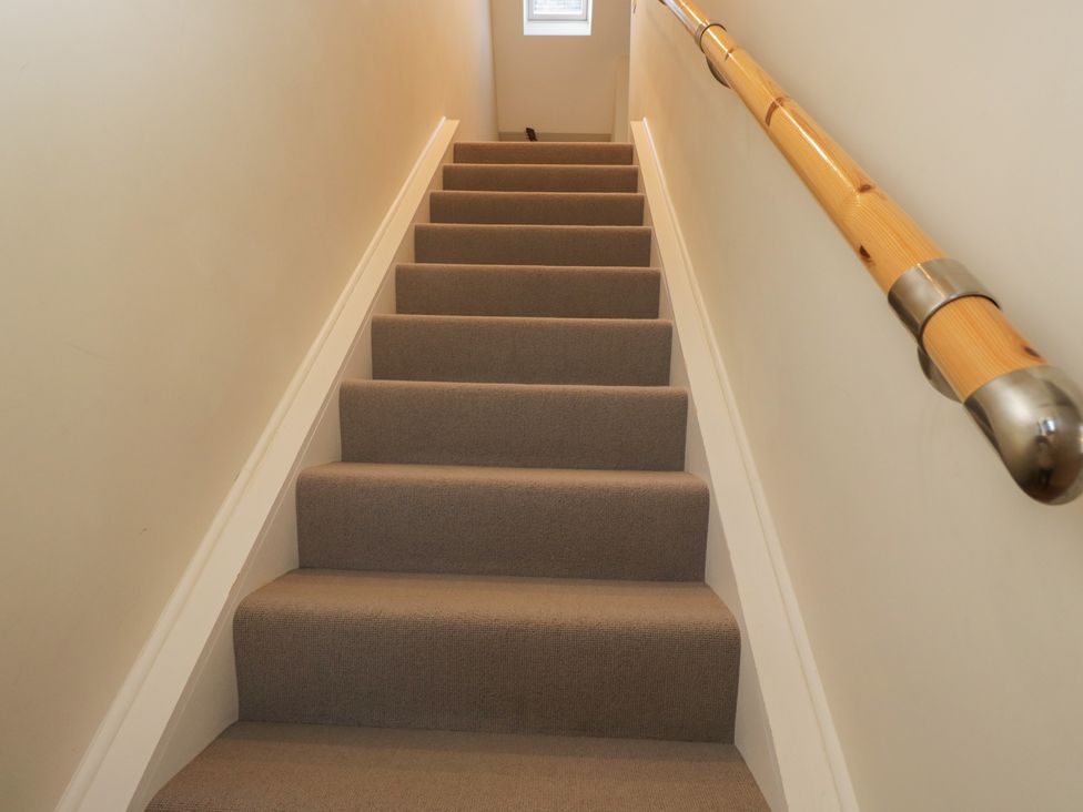 A staircase with carpet and a handrail at Flat 6