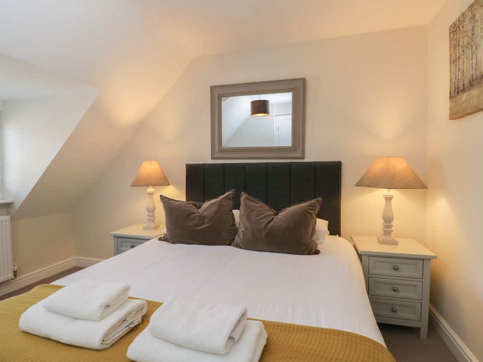 A bedroom with a bed and lamps at Flat 6