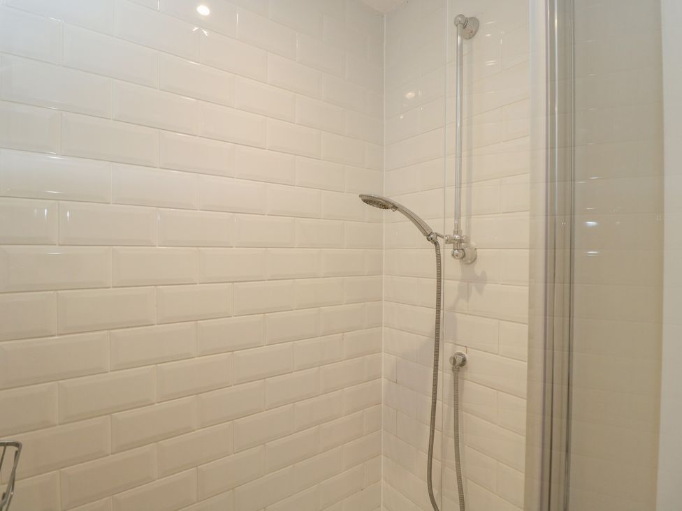 A shower area with tiles and shower fixtures at Flat 6 in 