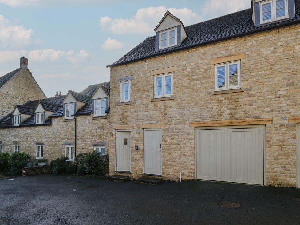 A stone building with windows and a garage door at Flat 6 