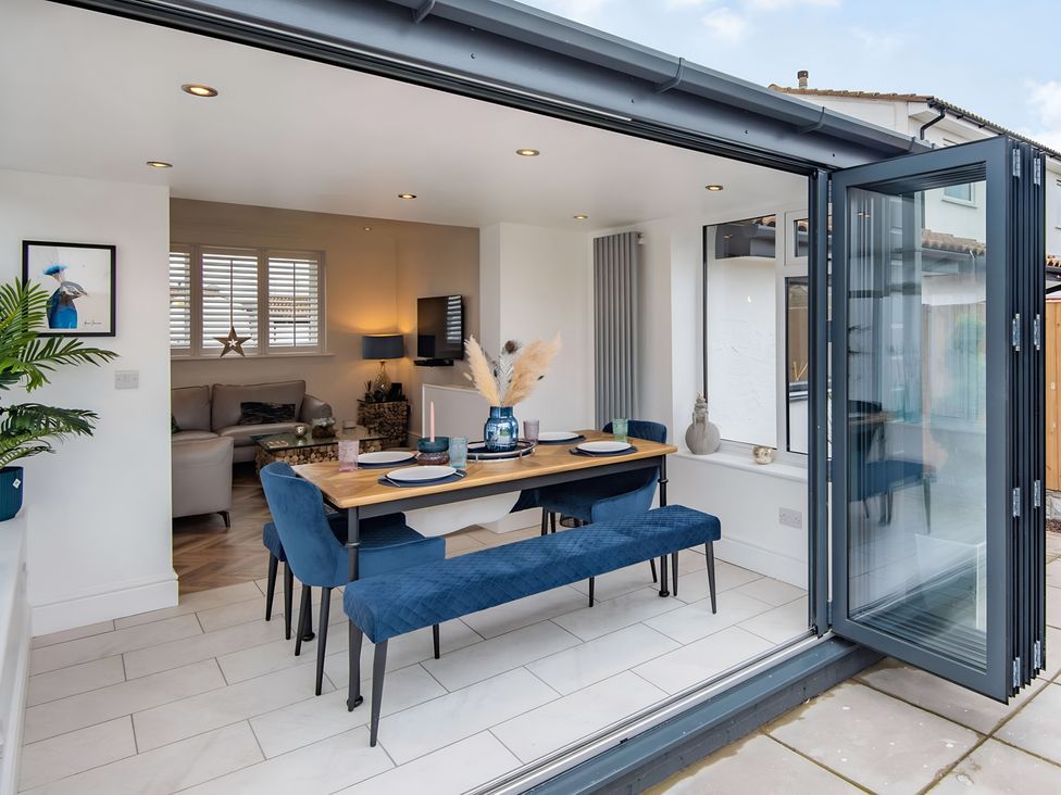 A dining room with a table and chairs at 6 Tegafan Abergele