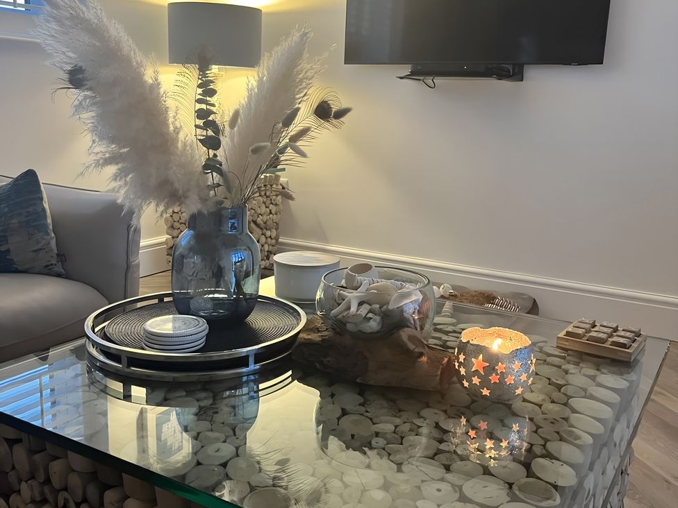 A living room with a coffee table and vase at 6 Tegafan Abergele