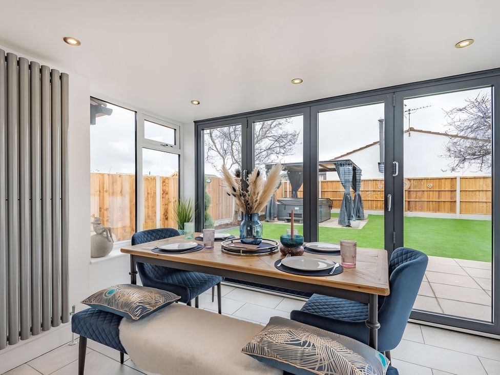 A dining room with a table and chairs at 6 Tegafan Abergele