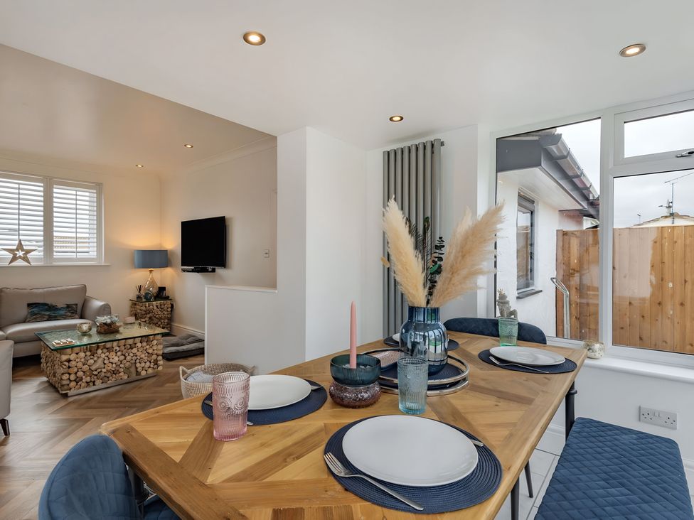 A dining room with a table and chairs at 6 Tegafan Abergele