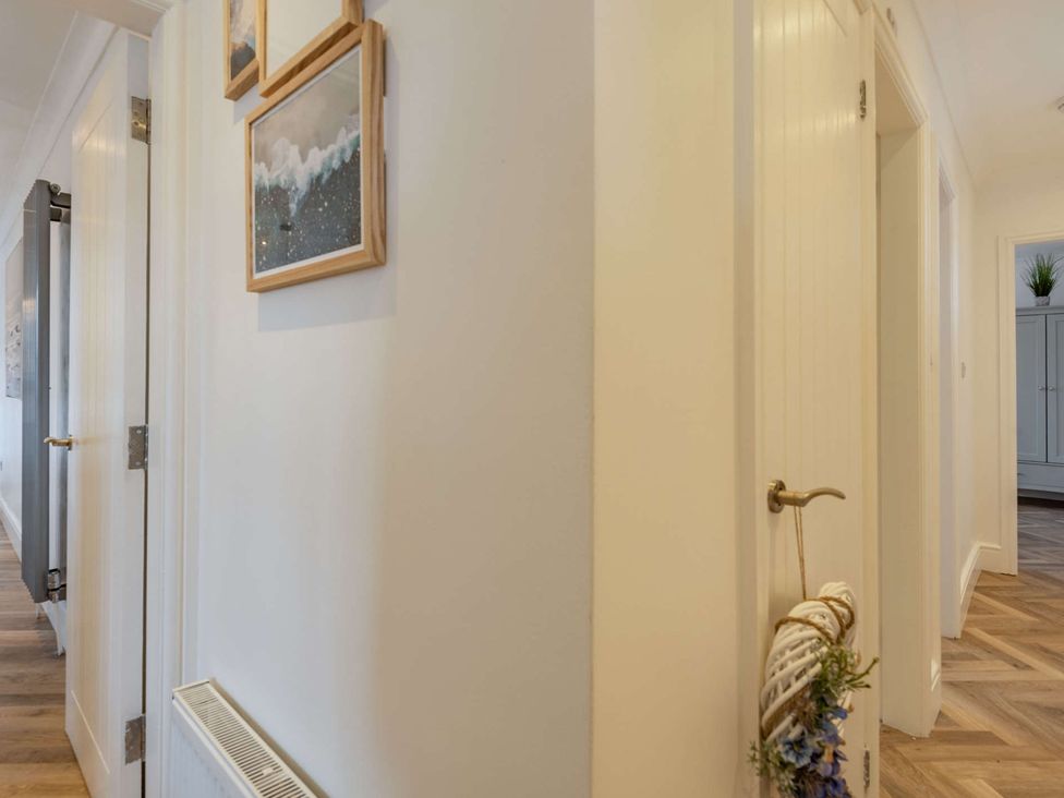 A hallway with picture frames and doors at 6 Tegafan in Abergele