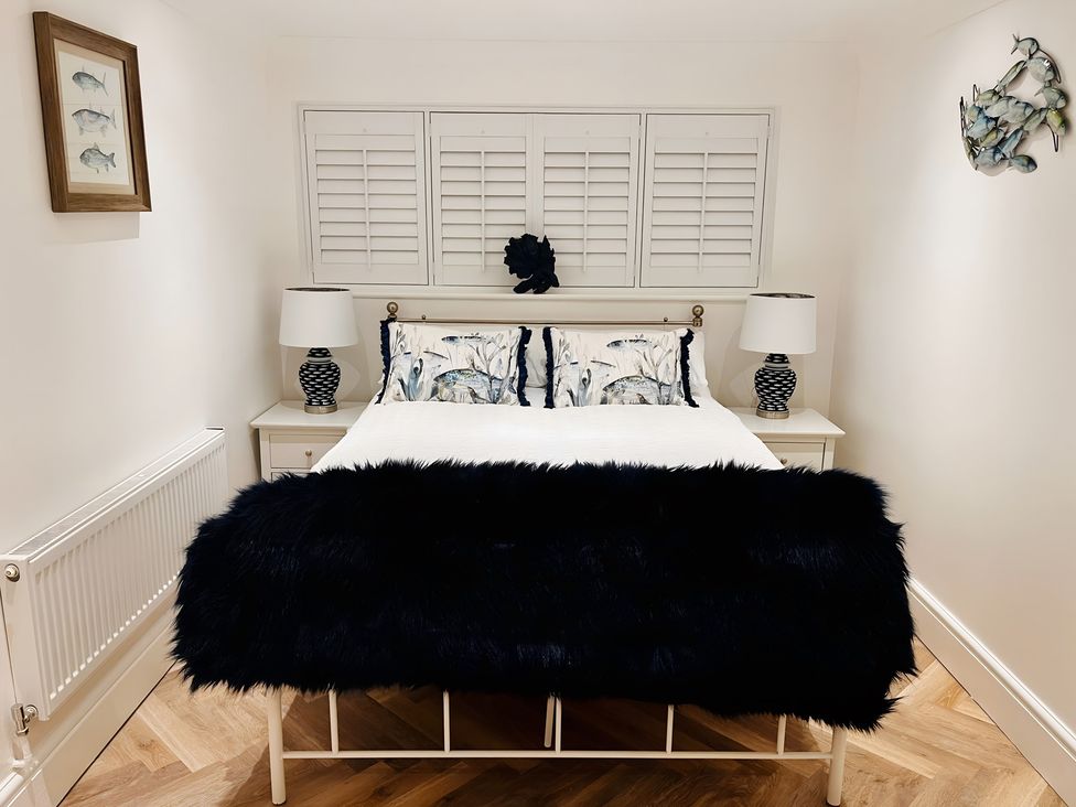 A bedroom with a bed, nightstands and lamps at 6 Tegafan in Abergele