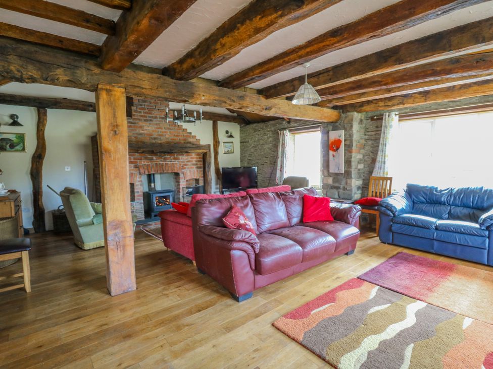 A living room with a fireplace and seating at Glanyrafon Smithy in Llandysul