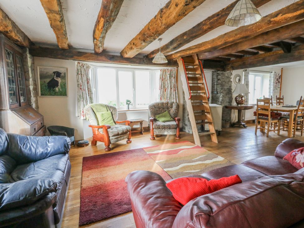 A living room with armchairs and a dining area at Glanyrafon Smithy, Llandysul
