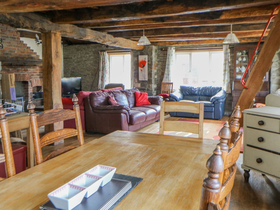 A living room with a sofa, table, and television at Glanyrafon Smithy in Llandysul