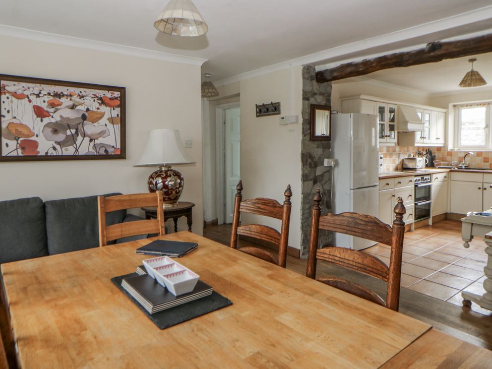 A dining room with a table and chairs at Glanyrafon Smithy in Llandysul