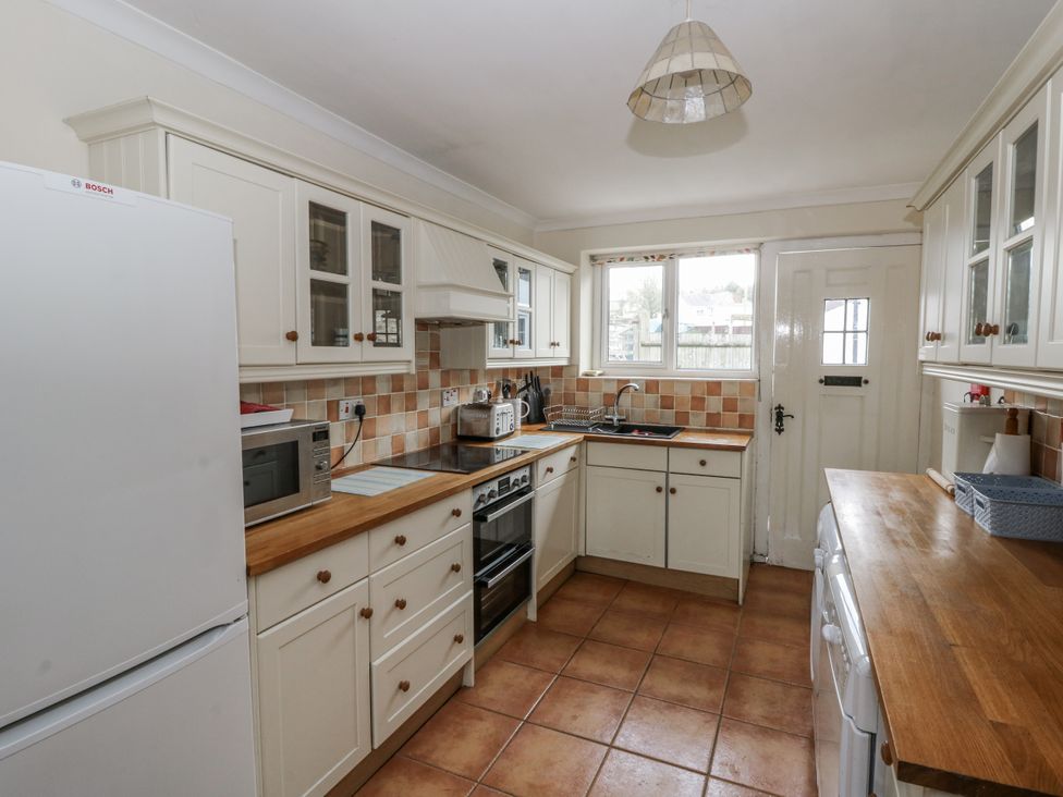A kitchen with cabinets and appliances at Glanyrafon Smithy in Llandysul