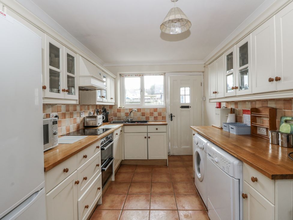 A kitchen with a washing machine and appliances at Glanyrafon Smithy in Llandysul