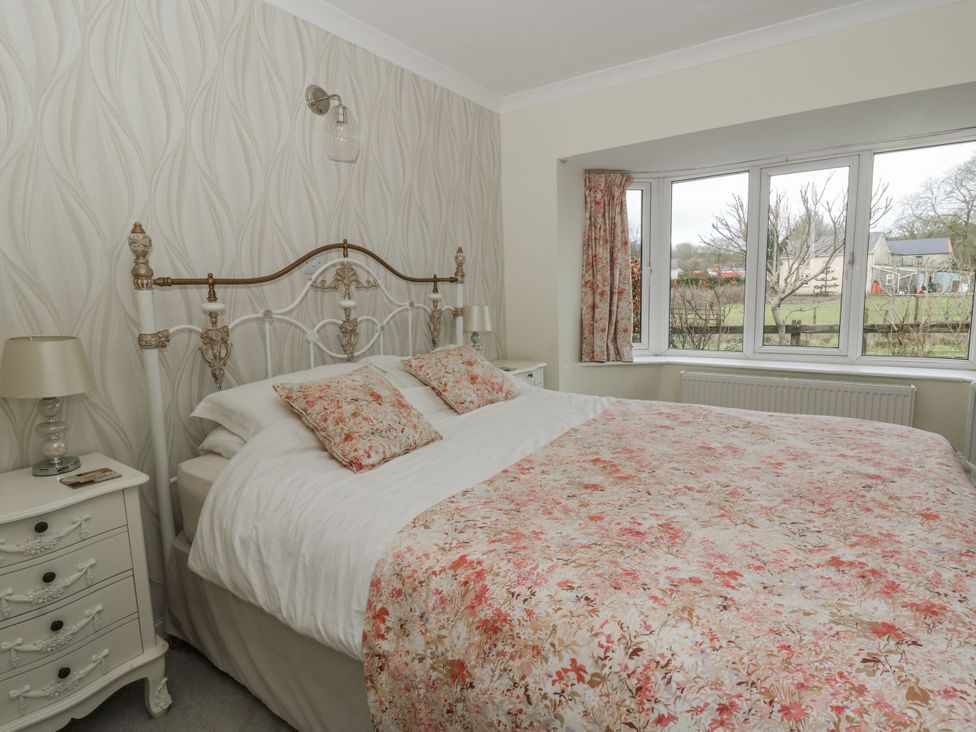 A bedroom with a bed and window at Glanyrafon Smithy in Llandysul