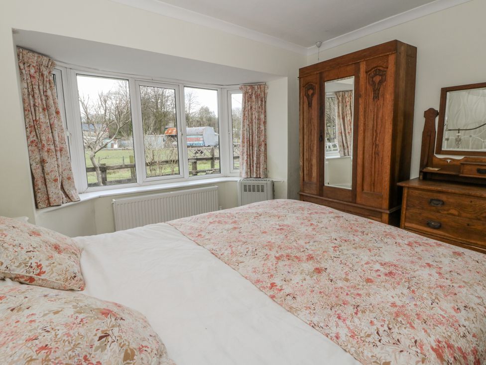 A bedroom with a bed and wardrobe at Glanyrafon Smithy in Llandysul