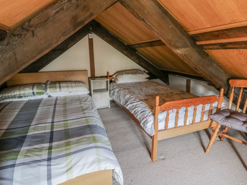 A bedroom with a double bed and a single bed at Glanyrafon Smithy in Llandysul