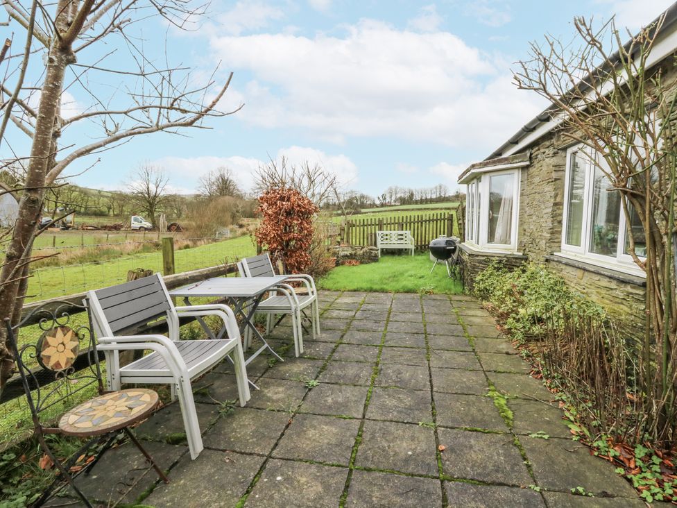A garden with patio chairs and table at Glanyrafon Smithy in Llandysul