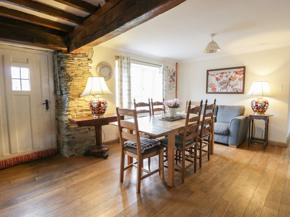 A dining room with a table and chairs at Glanyrafon Smithy in New Quay