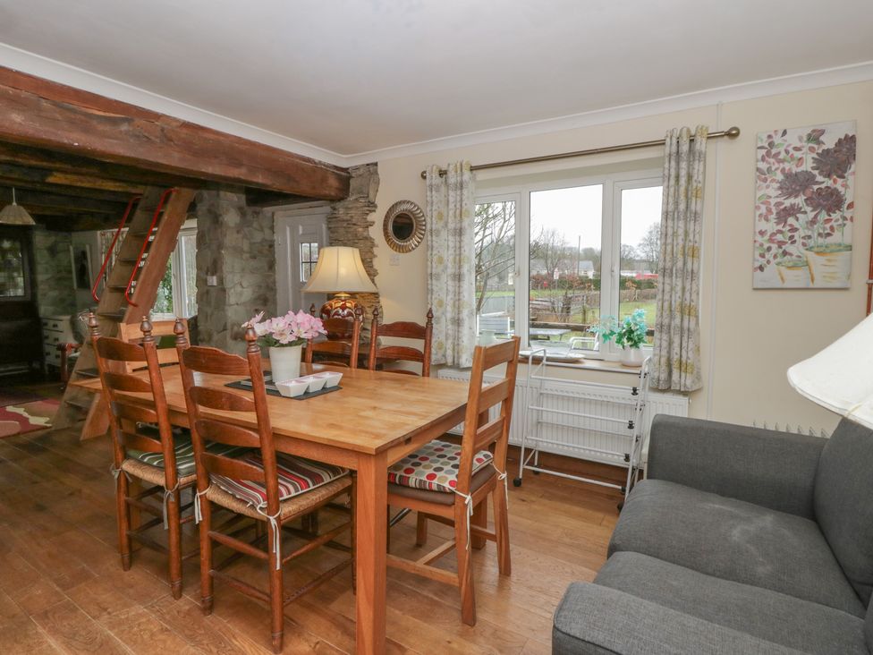 A dining room with a table and chairs at Glanyrafon Smithy New Quay