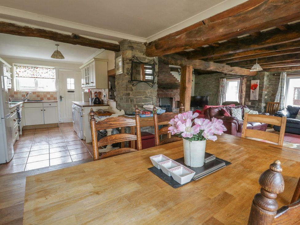 A kitchen with dining table and living area at Glanyrafon Smithy New Quay