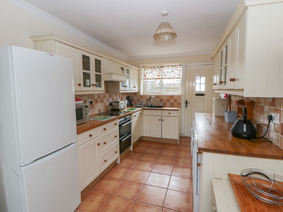 A kitchen with appliances and wooden countertops at Glanyrafon Smithy in New Quay