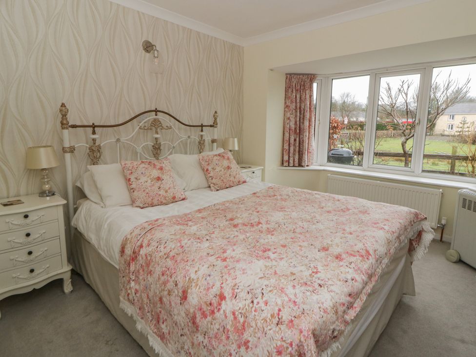 A bedroom with a bed and window at Glanyrafon Smithy in New Quay