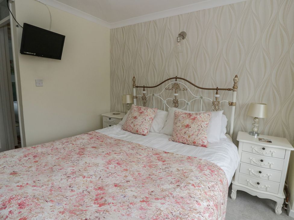 A bedroom with a bed and bedside tables at Glanyrafon Smithy in New Quay