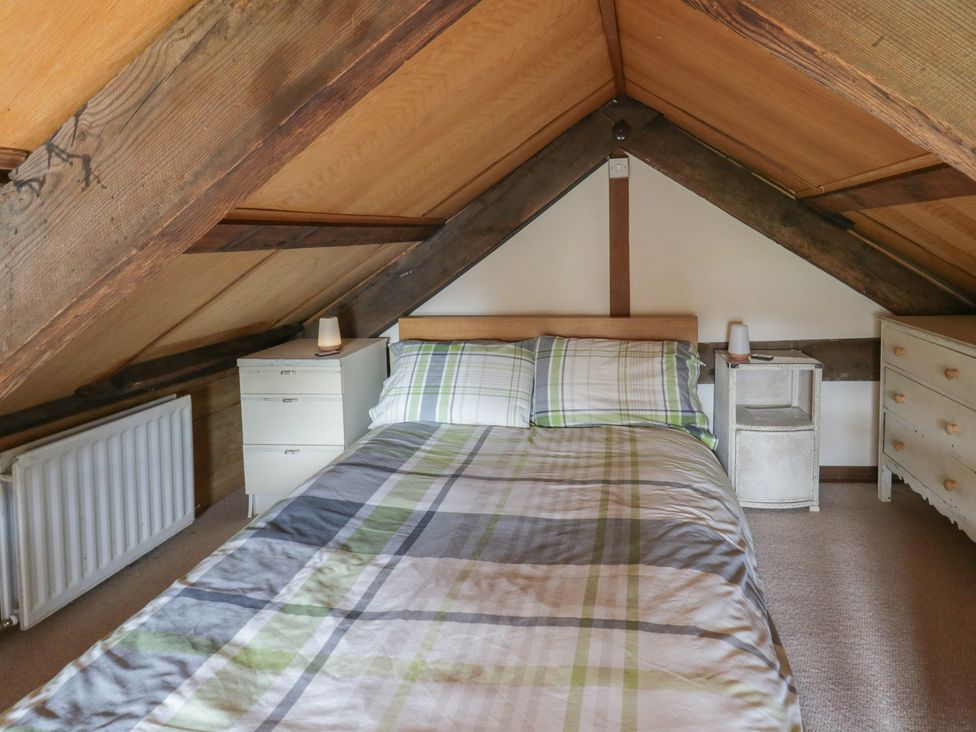 A bedroom with a bed and bedside tables at Glanyrafon Smithy in New Quay